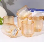 Shop the Golden Pebble Glass Tumbler at Dollar Empire, featuring a stylish golden-amber color and unique textured finish for everyday drinks.
